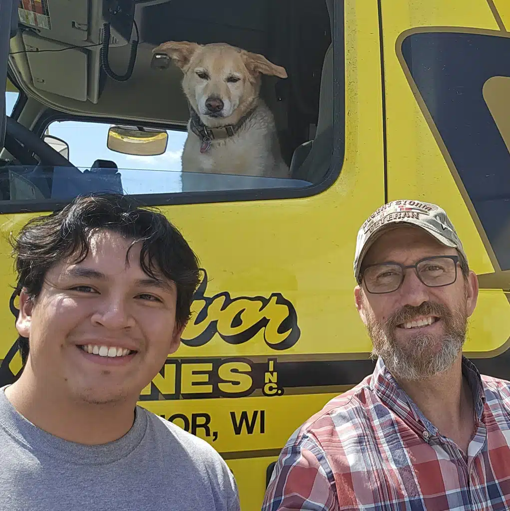 Stacey P., left with his trainee Luis. Stacey's dog Tobi watches from the truck.